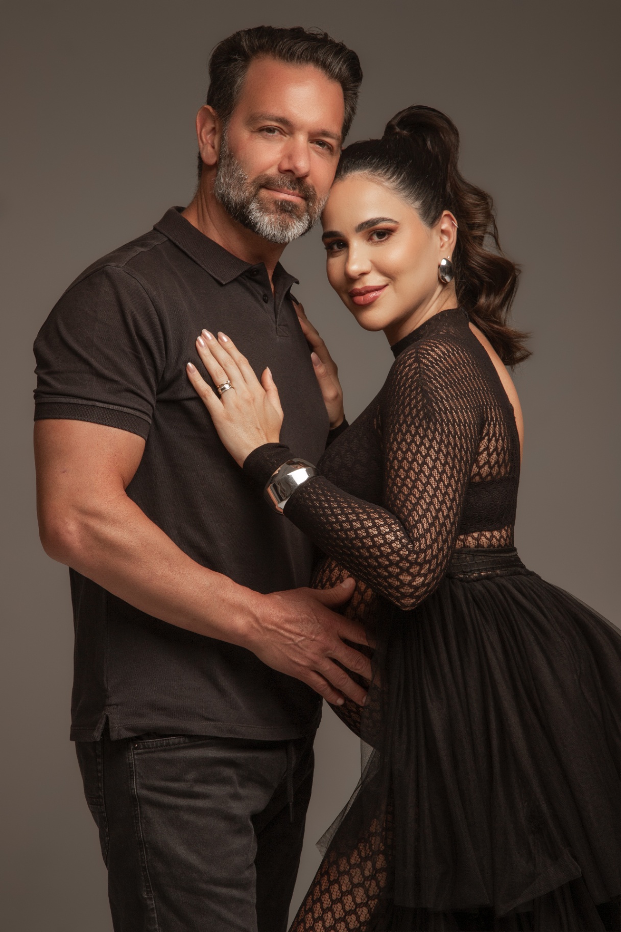 Casal gestante em ensaio editorial em tons escuros